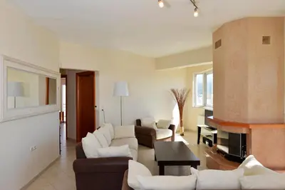 a living room with white furniture and a fireplace at Elia Selinou in Chania Town