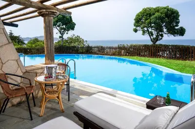 a patio with a pool and a table and chairs at Leptos Panorama Hotel in Kalamaki Chanion