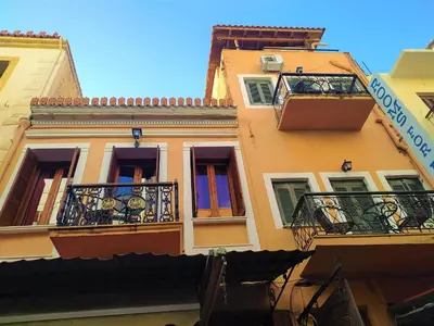 a yellow building with balconies and a sign on it at Diporto in Chania Town