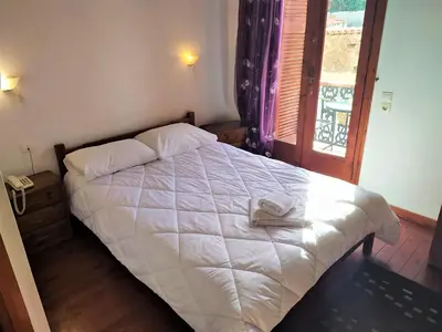 a bedroom with a white bed with a towel on it at Diporto in Chania Town