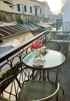 a table with a vase of flowers on a balcony at Diporto in Chania Town