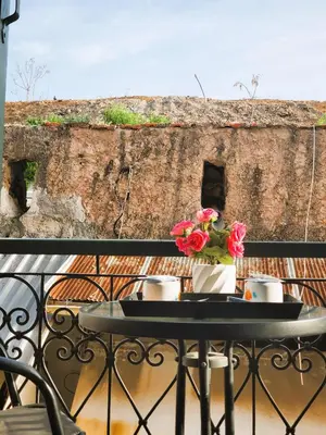 a table with flowers on top of a balcony at Diporto in Chania Town