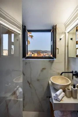 a bathroom with a sink and a large window at Porto Del Colombo Traditional Boutique Hotel in Chania Town