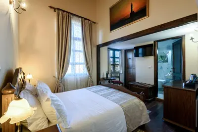 a hotel room with a bed and a window at Porto Del Colombo Traditional Boutique Hotel in Chania Town