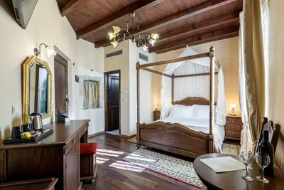 a bedroom with a canopy bed with a desk and a table at Porto Del Colombo Traditional Boutique Hotel in Chania Town