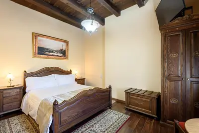 a bedroom with a wooden bed and a wooden cabinet at Porto Del Colombo Traditional Boutique Hotel in Chania Town