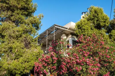 a building with flowering trees in front of it at Villa AERAS in Kato Daratso