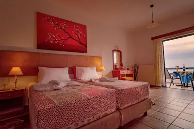 a bedroom with a bed with a red painting on the wall at Roula Apartments in Palaiochóra