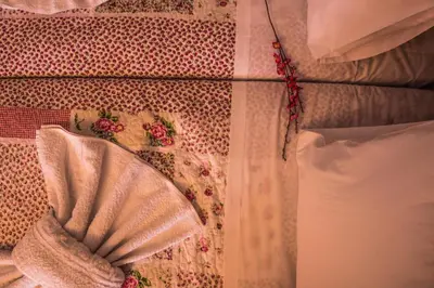 a white curtain with a flower on a bed at Roula Apartments in Palaiochóra