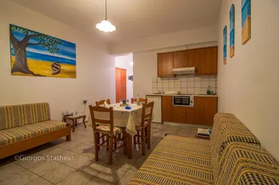 a kitchen and dining room with a table and chairs at Roula Apartments in Palaiochóra