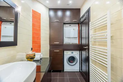 a bathroom with a washing machine and a washer and dryer at Evgenias Luxury Apartment with Rooftop Pool in Chania Town