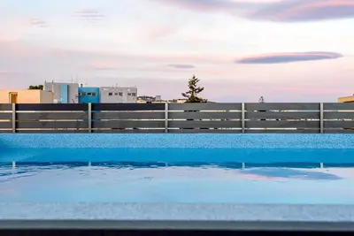 a swimming pool with a fence and some water at Evgenias Luxury Apartment with Rooftop Pool in Chania Town