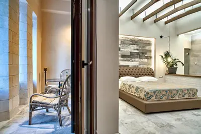 a bedroom with a bed and a table and chairs at Minoos Hotel in Chania Town