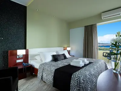 a hotel room with a bed with towels on it at Eleftheria Hotel in Agia Marina Nea Kydonias