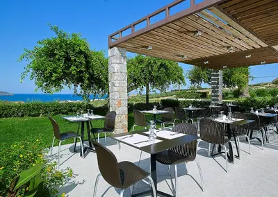a restaurant with tables and chairs under a pavilion at Eleftheria Hotel in Agia Marina Nea Kydonias