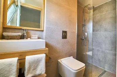 a bathroom with a toilet and a glass shower at Bella Pais in Maleme