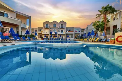 a swimming pool at a resort with chairs and condos at Bella Pais in Maleme