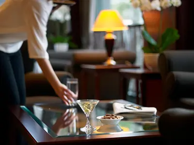 a person reaching for a drink on a glass table at Samaria Hotel in Chania Town