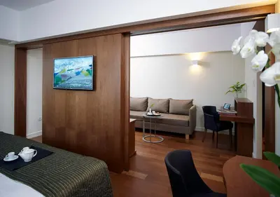 a living room with a couch and a tv on a wall at Samaria Hotel in Chania Town