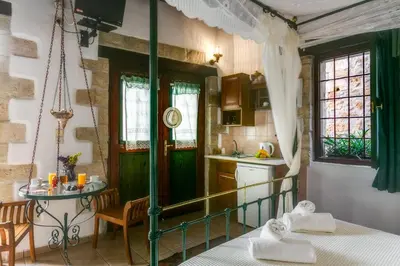 a kitchen with a bed and a table in a room at Ifigenia Rooms in Chania Town