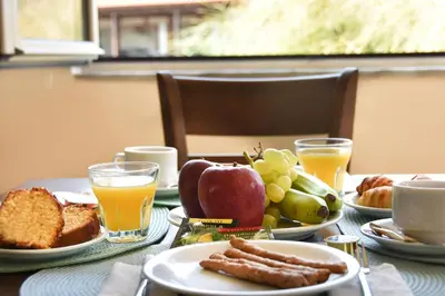 a table topped with plates of breakfast foods and orange juice at GT Beach in Maleme
