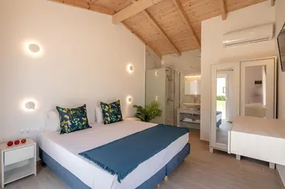 a bedroom with a large bed and a bathroom at GT Beach in Maleme