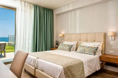 a bedroom with a large bed and a large window at Eland Dream Villas in Kalamaki Chanion