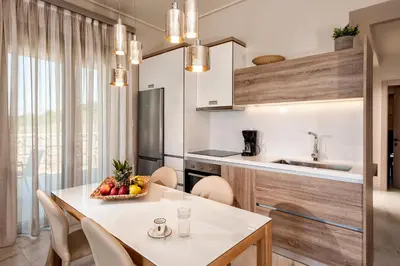 a kitchen with a table with a bowl of fruit on it at Eland Dream Villas in Kalamaki Chanion
