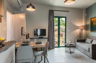 a kitchen and living room with a table and a couch at Casa Giulietta Modern Luxury Maisonette in Chania Town