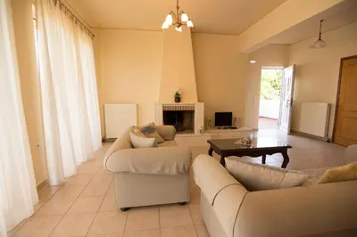 a living room with two couches and a fireplace at Beachway home in Kato Daratso