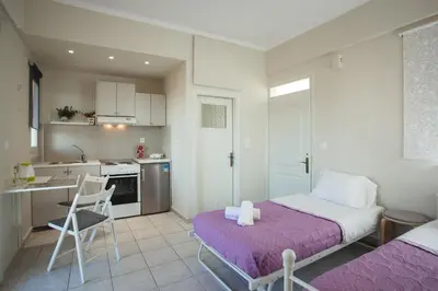 a small bedroom with a bed and a kitchen at Popy's Place in Kato Daratso