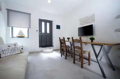 a living room with a table and chairs and a tv at Evans House in Chania Town