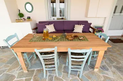 a dining room table with chairs and a purple couch at Aoria Traditional House with Stuning Mountain View in Loúlos