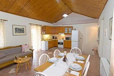 a living room with a dining table and a kitchen at Aoria Traditional House with Stuning Mountain View in Loúlos