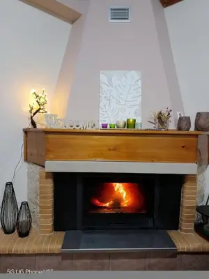 a fireplace in a living room with a fire place at Aoria Traditional House with Stuning Mountain View in Loúlos