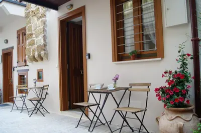 a patio with a table and chairs next to a building at Casa al Bocca del Porto in Chania Town