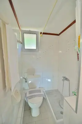 a white bathroom with a toilet and a shower at Eliana in Kissamos
