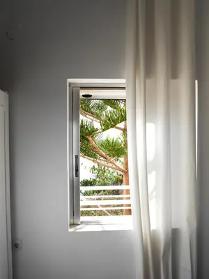 an open door with a window with a tree outside at Georgia in Palaiochóra