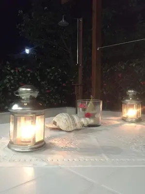 a table with three candles and a shell with a bowl of fruit at The Endless Blue Maisonette in Palaiochóra