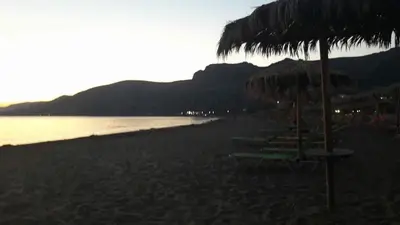 a beach with some chairs and umbrellas on it at The Endless Blue Maisonette in Palaiochóra