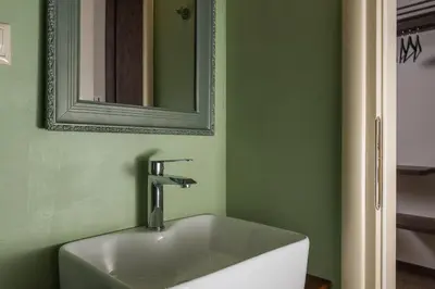 a sink in a green bathroom with a mirror at Nonnalena Boutique Hotel in Chania Town