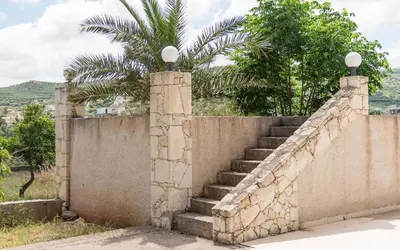 an old stone wall with stairs and a palm tree at Xirouchakis farm in Kissamos
