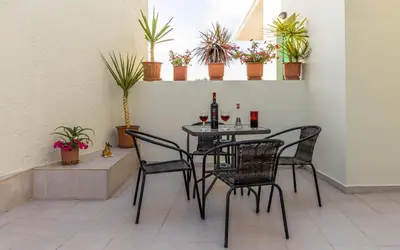 a table with chairs and wine bottles and plants at Xirouchakis farm in Kissamos