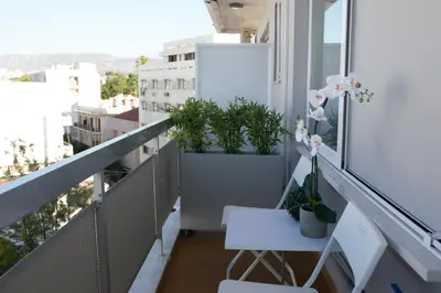 a balcony with potted plants and a table at DYO Urban Chania in Chania Town