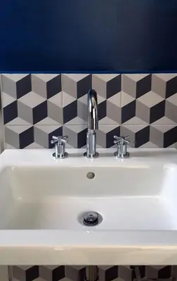 a bathroom sink with a black and white checkered wall at DYO Urban Chania in Chania Town