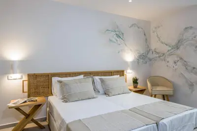 a bedroom with a large bed and a painting on the wall at Eleana Nature & Art in Khóra Sfakíon