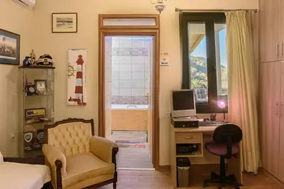 a bedroom with a desk with a computer and a chair at Villa Roxani in Mesklá