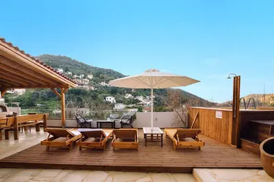 a patio with tables and chairs and an umbrella at Villa Roxani in Mesklá