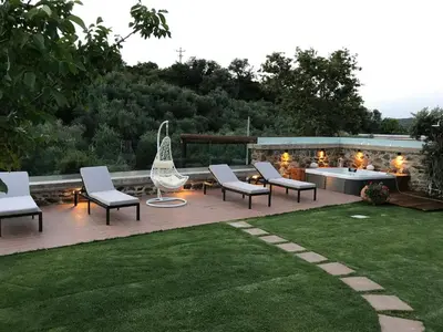 a patio with chairs and a table with lights at Villa Casa Avocado in Tavronitis