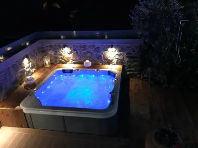 a hot tub with lights in a backyard at night at Villa Casa Avocado in Tavronitis